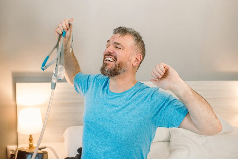 man stretching contentedly after using cpap machine for sleep apnea treatment