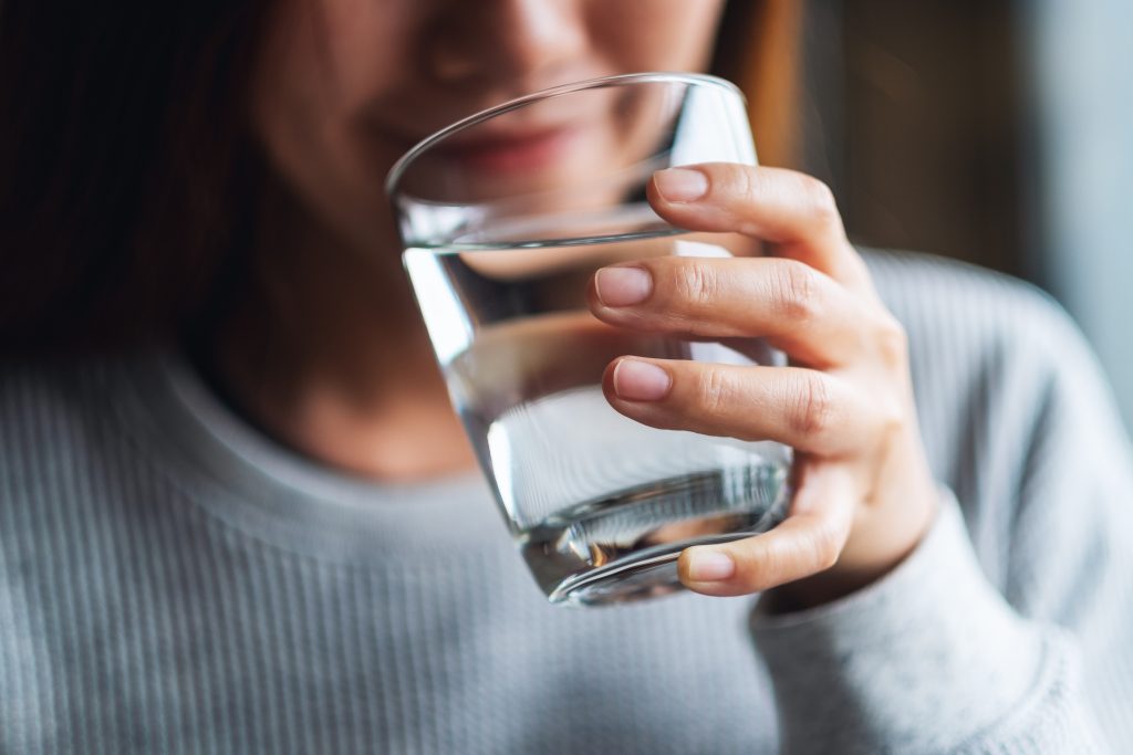 Closeup image of a beautiful young asian woman holding a glass o